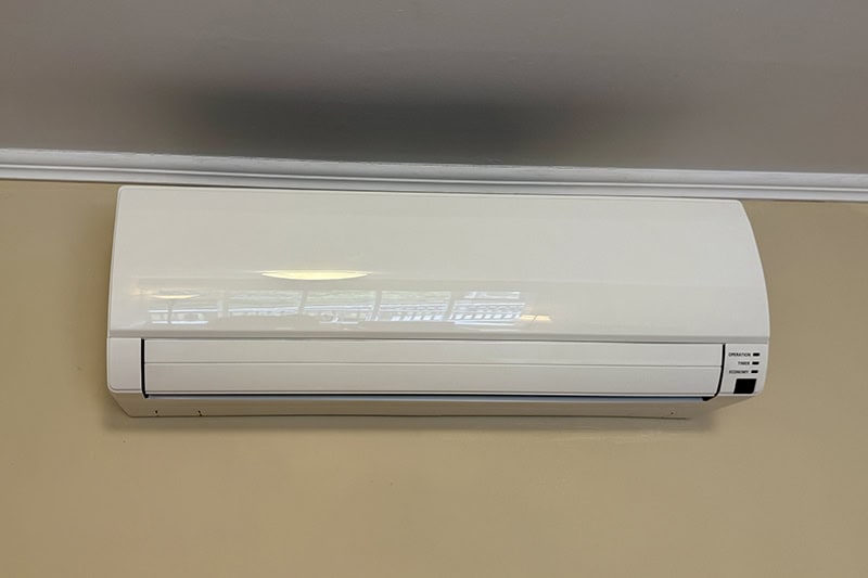 A white ductless unit hanging on a wall